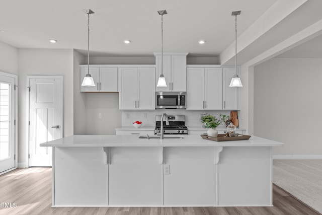 kitchen with light countertops, white cabinets, appliances with stainless steel finishes, and a sink