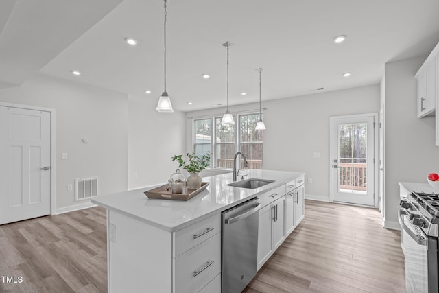 kitchen with visible vents, light countertops, light wood-style flooring, stainless steel appliances, and a sink