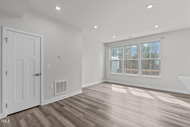 empty room with visible vents, baseboards, and wood finished floors