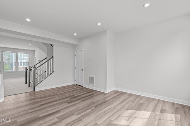 unfurnished room featuring recessed lighting, visible vents, baseboards, and stairs