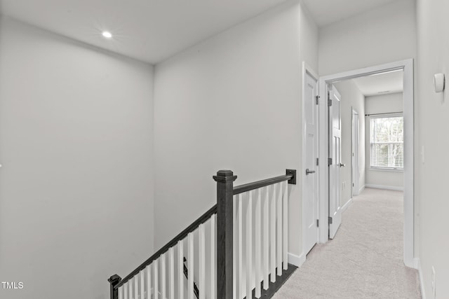 hallway with recessed lighting, an upstairs landing, light colored carpet, and baseboards