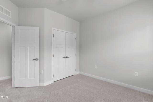 unfurnished bedroom with visible vents, carpet floors, baseboards, and a closet