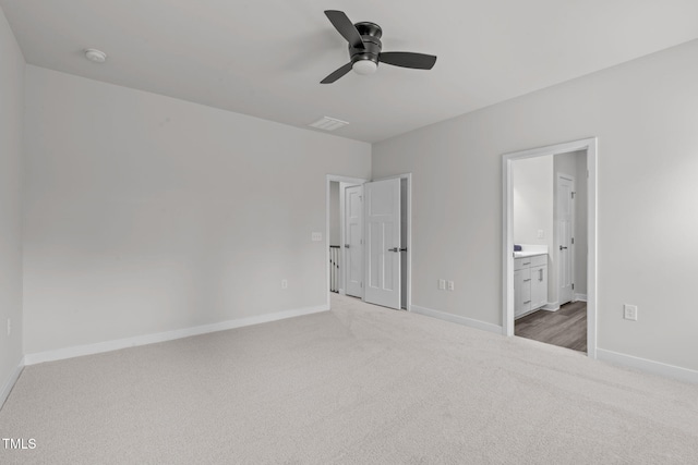 unfurnished bedroom with visible vents, a ceiling fan, ensuite bathroom, carpet flooring, and baseboards