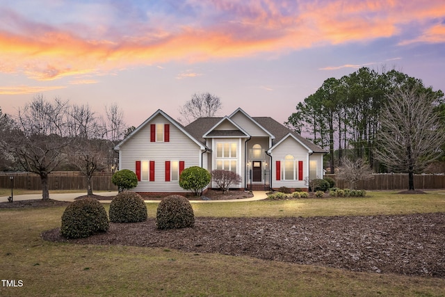 view of front facade featuring a front lawn and fence