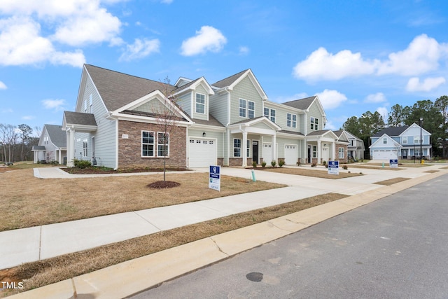 view of front of home featuring a garage, stone siding, and driveway