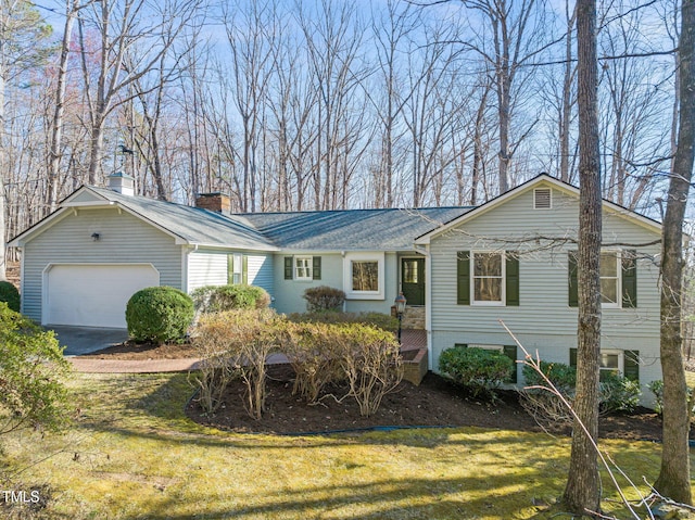 single story home with an attached garage, a chimney, concrete driveway, and a front lawn