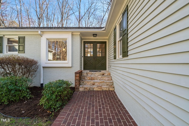 doorway to property featuring brick siding