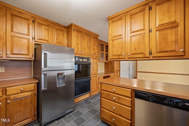 kitchen with light countertops, brown cabinetry, and appliances with stainless steel finishes