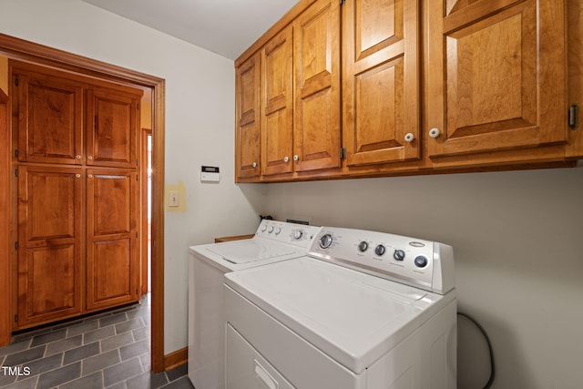 laundry area featuring cabinet space, baseboards, and washing machine and clothes dryer