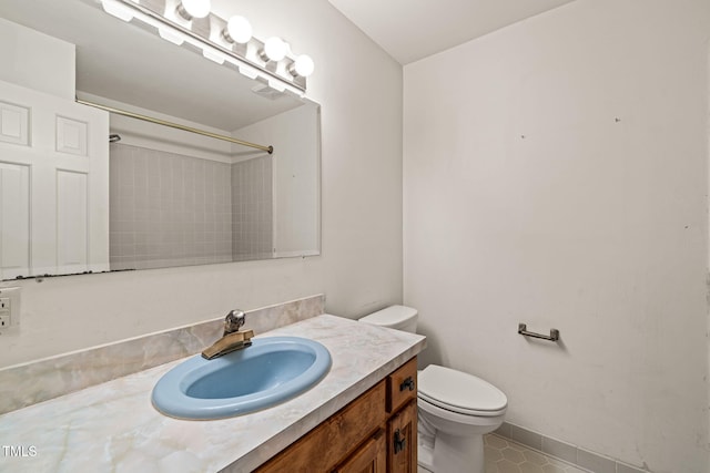 full bath with tile patterned flooring, baseboards, walk in shower, toilet, and vanity