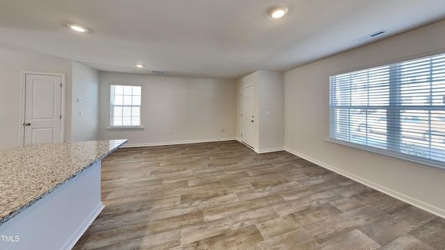 interior space with visible vents, baseboards, and wood finished floors