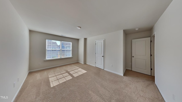 carpeted empty room featuring baseboards