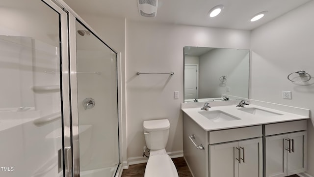 full bath featuring double vanity, toilet, a stall shower, and a sink