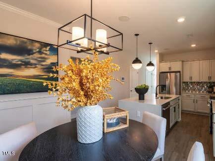 dining area with dark wood-style floors, recessed lighting, and crown molding