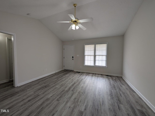 unfurnished living room featuring wood finished floors, a ceiling fan, baseboards, and vaulted ceiling