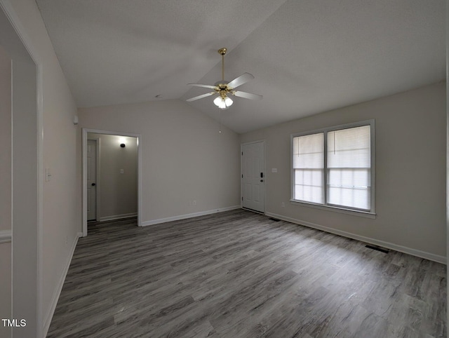 unfurnished room with vaulted ceiling, wood finished floors, and baseboards