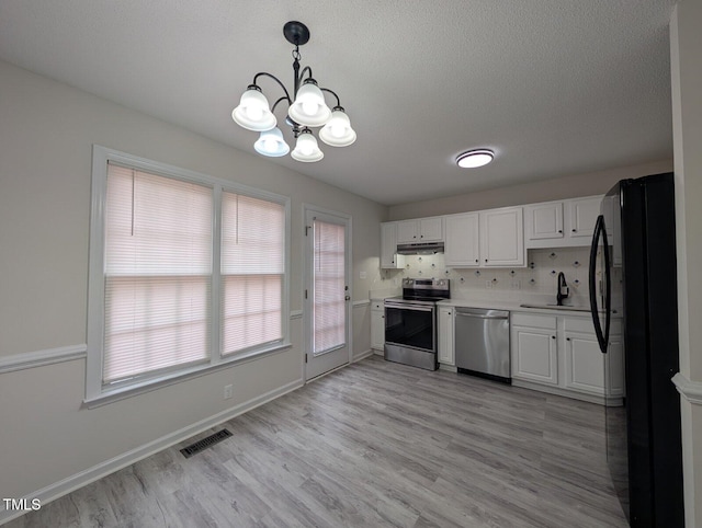 kitchen with visible vents, stainless steel appliances, light countertops, under cabinet range hood, and white cabinetry