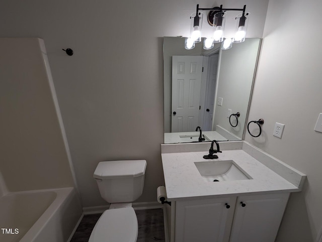 full bathroom featuring a bathtub, toilet, vanity, and baseboards