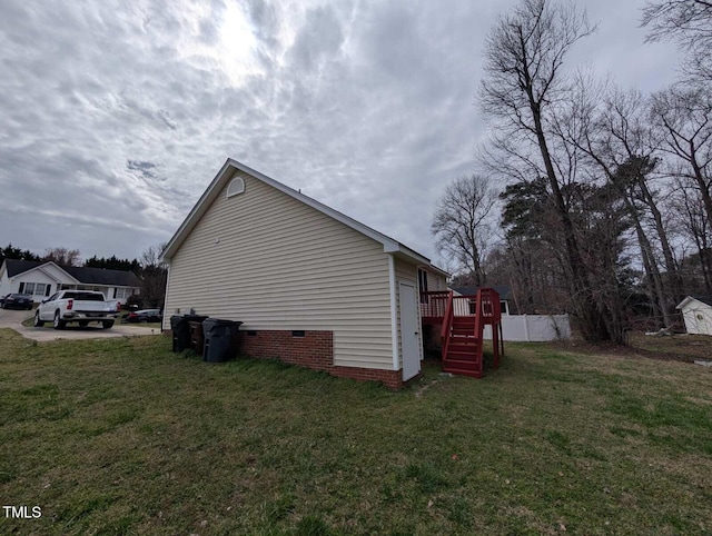 view of home's exterior with crawl space, a yard, and fence