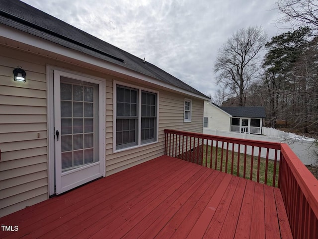 wooden deck featuring a lawn and fence