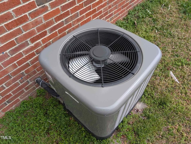 exterior details featuring cooling unit and brick siding