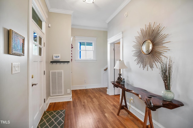 entrance foyer featuring crown molding, wood finished floors, visible vents, and baseboards