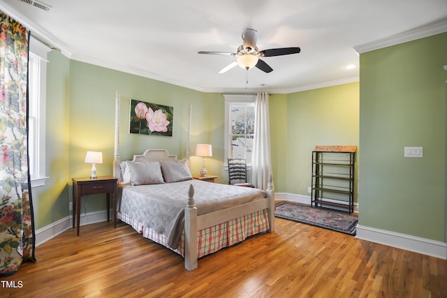 bedroom featuring crown molding, baseboards, and wood finished floors