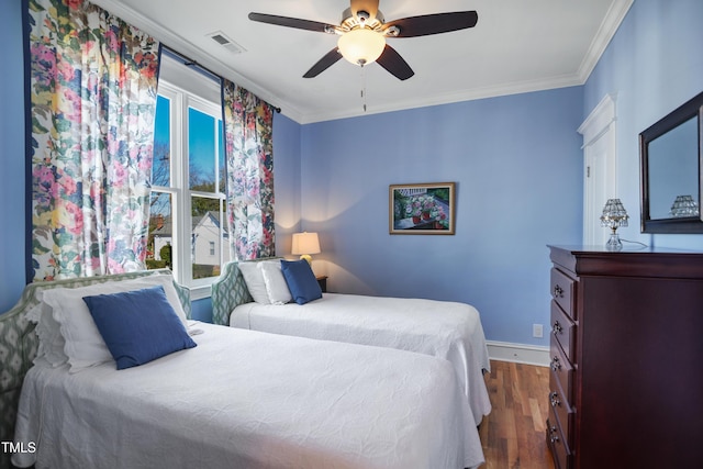 bedroom featuring crown molding, multiple windows, dark wood-style floors, and visible vents