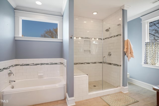 bathroom featuring toilet, ornamental molding, a shower stall, baseboards, and a bath