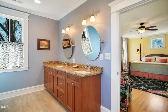 full bath featuring connected bathroom, wood finished floors, ornamental molding, and a sink