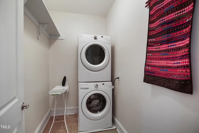 laundry room featuring laundry area, stacked washer / drying machine, and baseboards