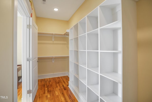 walk in closet with wood finished floors