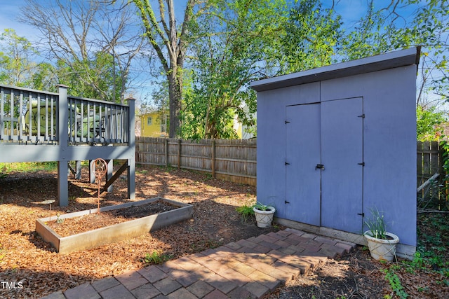 view of yard with a fenced backyard, a wooden deck, a storage shed, and an outdoor structure