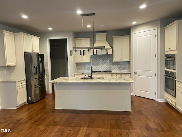 kitchen with visible vents, a center island with sink, appliances with stainless steel finishes, and dark wood-style flooring