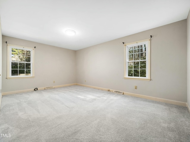 unfurnished room with visible vents, carpet flooring, and baseboards