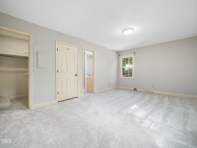 unfurnished bedroom featuring baseboards, carpet floors, visible vents, and a spacious closet