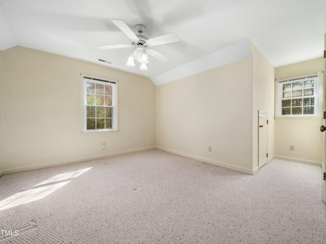 unfurnished room featuring visible vents, ceiling fan, carpet flooring, and vaulted ceiling