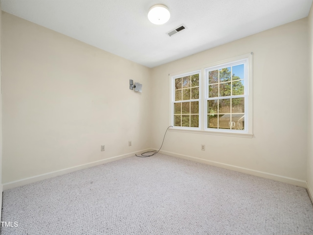 unfurnished room with visible vents, baseboards, and carpet flooring