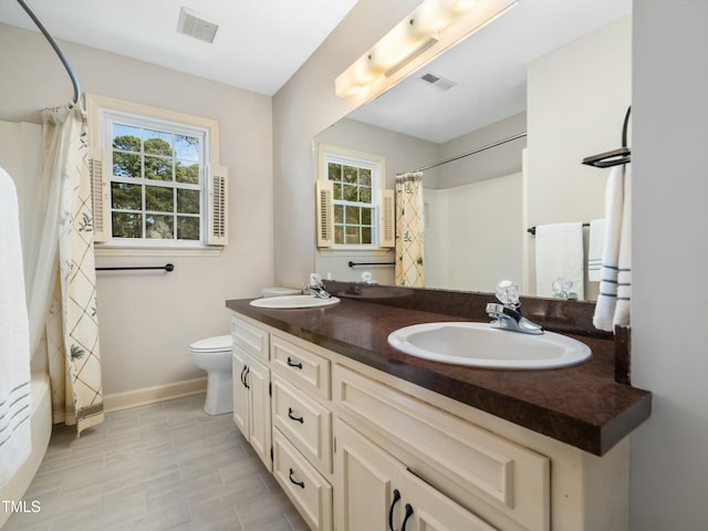 full bathroom with visible vents, toilet, and a sink