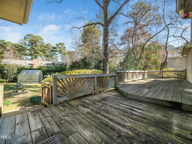 deck with a greenhouse and an outbuilding