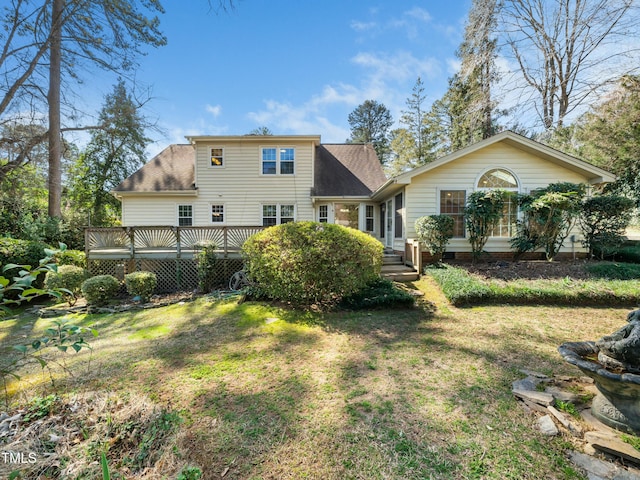 rear view of house featuring a wooden deck, crawl space, a lawn, and a shingled roof