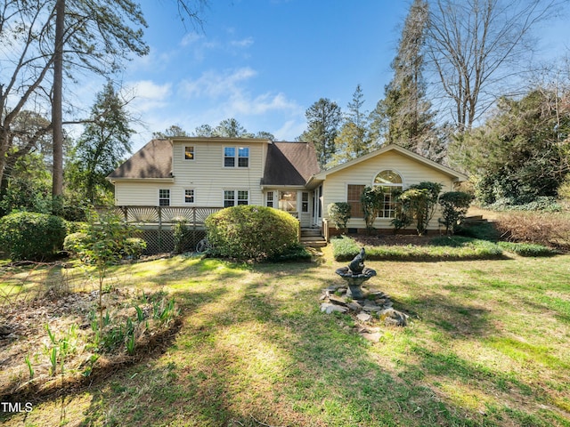 rear view of property with a lawn and roof with shingles