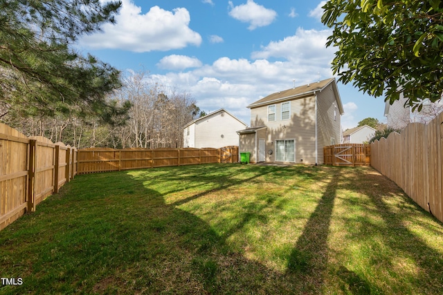 view of yard with a fenced backyard and a gate