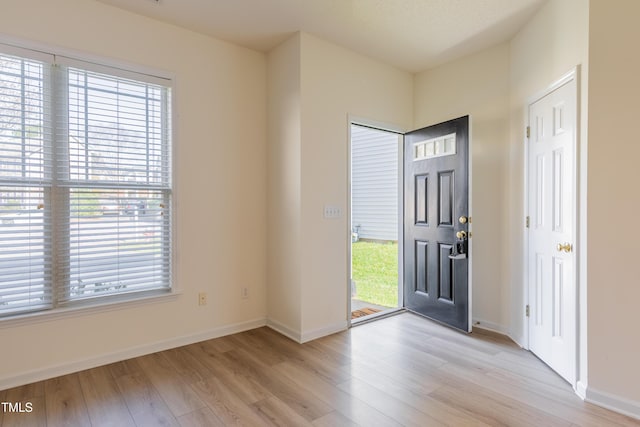 entryway with light wood-type flooring and baseboards