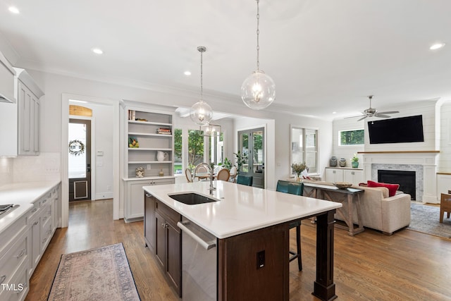 3337 Cheswick Dr, Raleigh, NC 27609 - kitchen featuring dishwasher, a fireplace, a ceiling fan, light countertops, and a breakfast bar area
