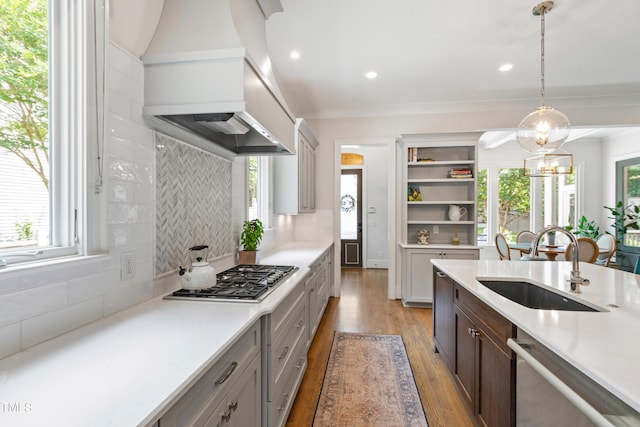 3337 Cheswick Dr, Raleigh, NC 27609 - kitchen with appliances with stainless steel finishes, custom exhaust hood, light countertops, light wood-style flooring, and tasteful backsplash