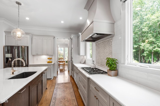 3337 Cheswick Dr, Raleigh, NC 27609 - kitchen featuring stainless steel appliances, premium range hood, light countertops, tasteful backsplash, and light wood-style flooring