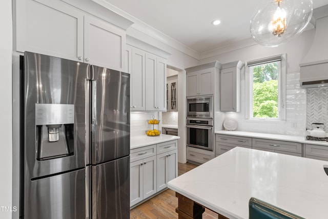 3337 Cheswick Dr, Raleigh, NC 27609 - kitchen featuring stainless steel appliances, decorative backsplash, light wood finished floors, crown molding, and pendant lighting