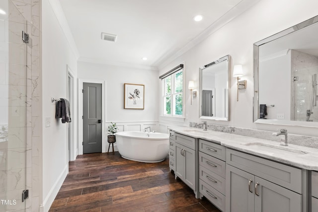 3337 Cheswick Dr, Raleigh, NC 27609 - bathroom with double vanity, crown molding, a marble finish shower, a freestanding bath, and hardwood / wood-style flooring