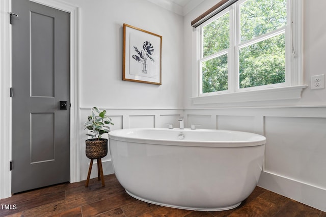 3337 Cheswick Dr, Raleigh, NC 27609 - bathroom with a freestanding tub, a decorative wall, wood finished floors, and a wainscoted wall